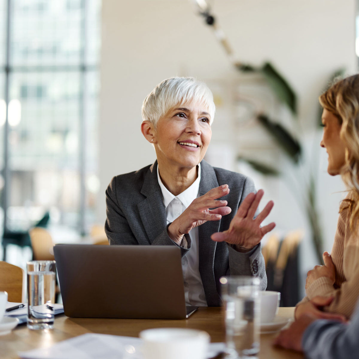 female Allworth advisor explain investment management while looking out over her laptop