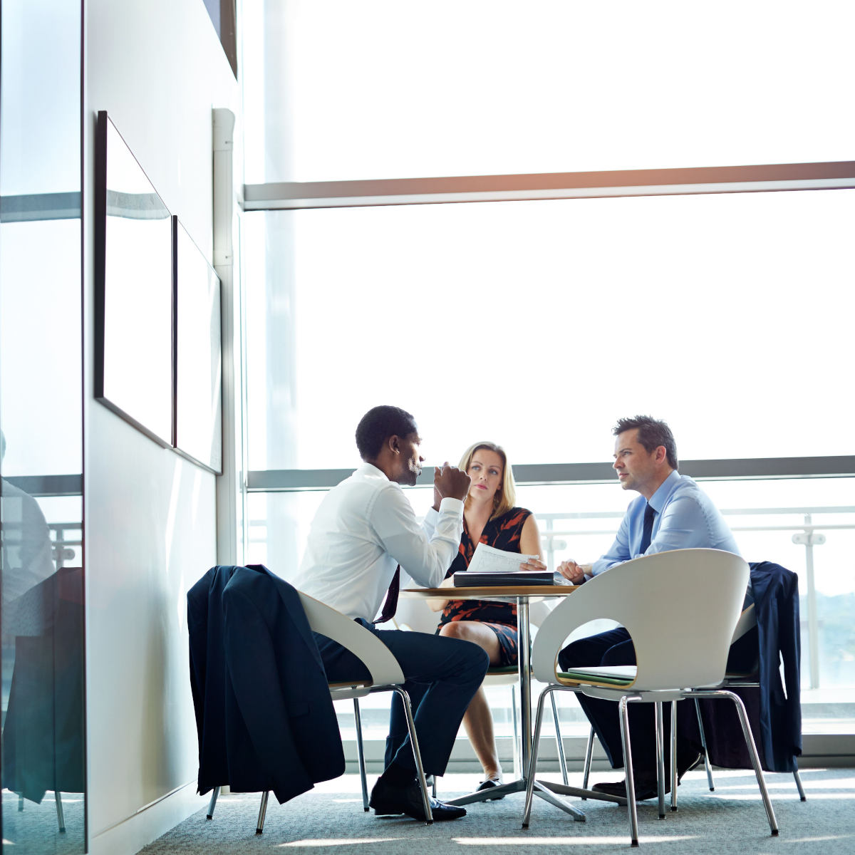 three tax planning professions have a discussion while sitting in a modern office