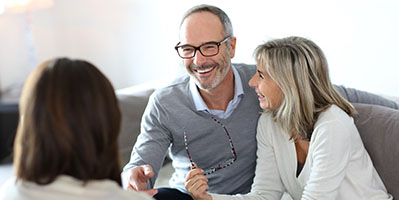 couple smiling and laughing as they meet with their advisor